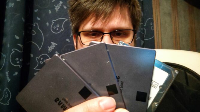 A person holding a bunch of SSDs like a hand of cards in a poker game.