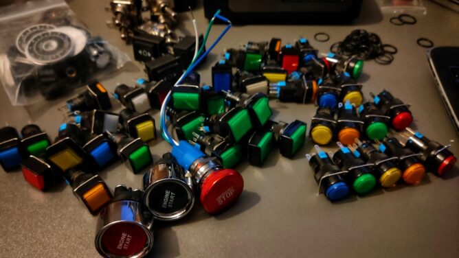 A desk full of various push buttons in many colours.